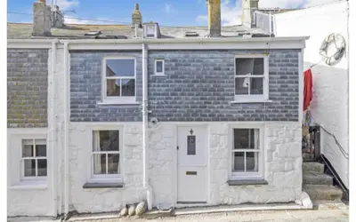 a white stone house with white doors and windows at SEA-AH-NA SIDE COTTAGE - Steps from the Beach Grade II Listed Refurbished Romantic Getaway in St Ives