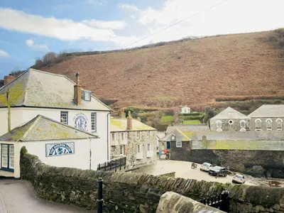a village with a stone wall and a building at Waves End - Port Isaac Cornwall in Port Isaac
