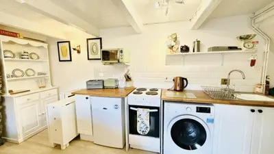 a kitchen with a washing machine and a sink at Waves End - Port Isaac Cornwall in Port Isaac