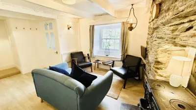 a living room with a blue couch and chairs at Waves End - Port Isaac Cornwall in Port Isaac