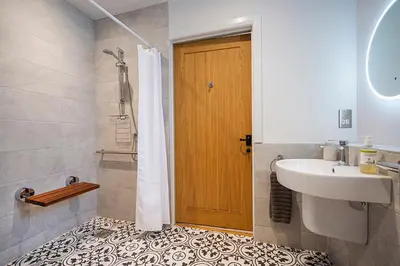 a bathroom with a sink and a shower with a shower curtain at Lowenna at Cusgarne Manor, rural, accessible in Cusgarne