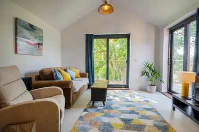 a living room with a couch and a table at Lowenna at Cusgarne Manor, rural, accessible in Cusgarne