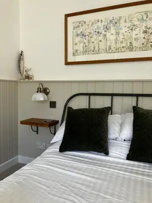 a bed with black pillows and a picture above it at Little Croft- Walking paradise close to St Ives in St Ives