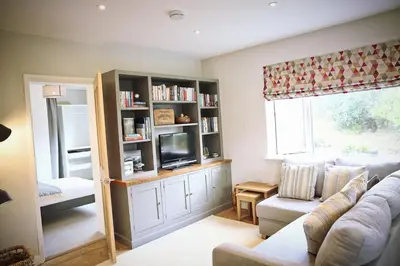 a living room with a couch and a tv at Little Croft- Walking paradise close to St Ives in St Ives