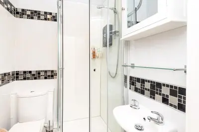 a bathroom with a shower and a toilet and a sink at Heart of Looe Apartment in Looe