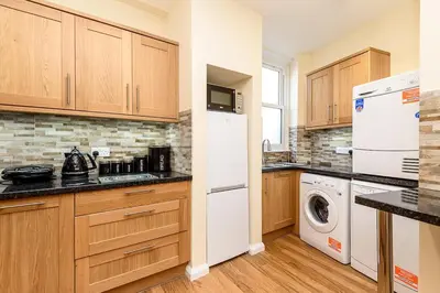 a kitchen with a white refrigerator and a washer and dryer at Heart of Looe Apartment in Looe