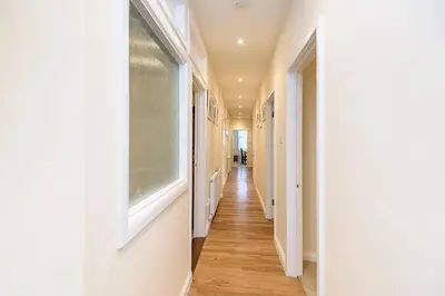 a hallway with white walls and a window at Heart of Looe Apartment in Looe