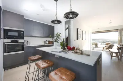 a kitchen with a large island with bar stools at 10 Cannery Row - Stunning Views - Pet Welcome - Free WiFi & Parking in Hayle