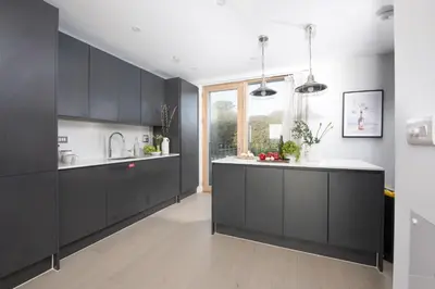 a kitchen with black cabinets and a white counter top at 10 Cannery Row - Stunning Views - Pet Welcome - Free WiFi & Parking in Hayle
