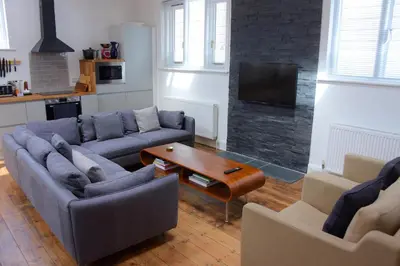 a living room with two couches and a table at Ebenezer Hall in Falmouth
