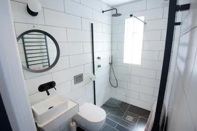 a white bathroom with a sink and a mirror at Ebenezer Hall in Falmouth