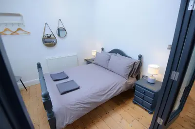 a bedroom with a bed with white sheets and pillows at Ebenezer Hall in Falmouth