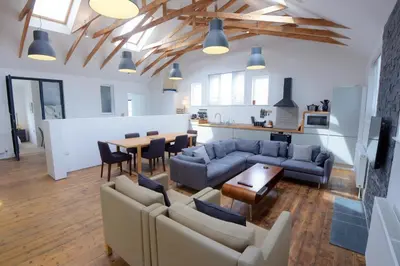 a living room with couches and a table and a kitchen at Ebenezer Hall in Falmouth