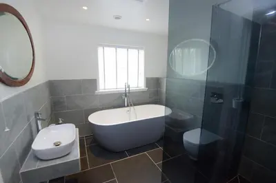 a bathroom with a tub and a toilet and a sink at Ebenezer Hall in Falmouth