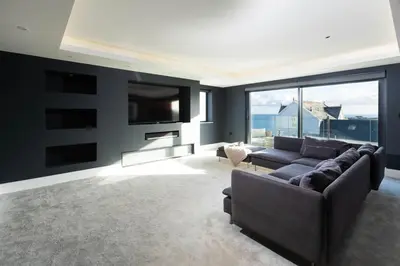 a living room with a couch and a tv at Seaglass Point in Mevagissey