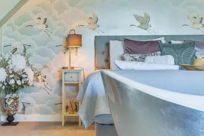 a bedroom with a bed with birds on the wall at Harbour Lights in Charlestown