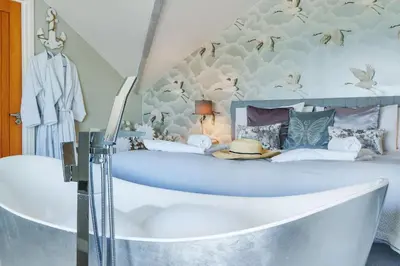 a bedroom with a large bed with a bath tub at Harbour Lights in Charlestown