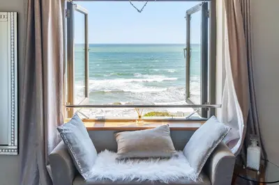 a chair in front of a window with the ocean at Harbour Lights in Charlestown