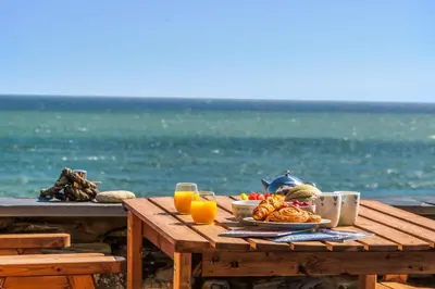 a picnic table with a plate of food on the beach at Harbour Lights in Charlestown