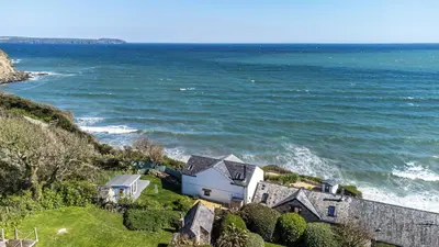 a house on a hill next to the ocean at Harbour Lights in Charlestown