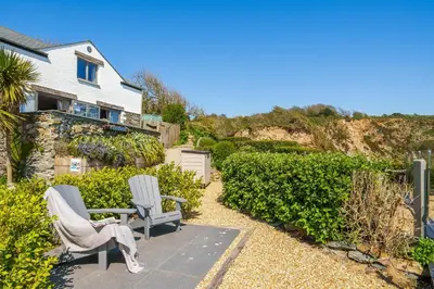 a patio with two chairs and a table in front of a house at Harbour Lights in Charlestown