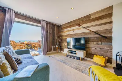 a living room with a blue couch and a tv at Harbour Lights in Charlestown