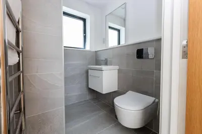 a bathroom with a toilet and a sink and a mirror at Ocean Skies in Porthtowan