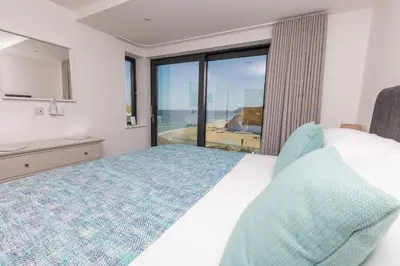 a bedroom with a bed and a view of the ocean at Ocean Skies in Porthtowan