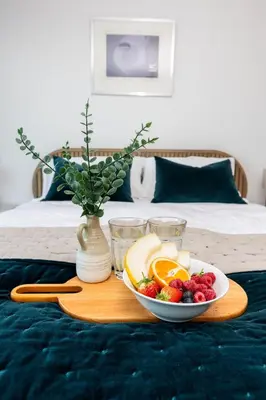 a tray with a plate of fruit on a bed at Ocean Skies in Porthtowan
