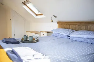 a bedroom with a blue bed with two pillows at Oceans Edge in Portreath