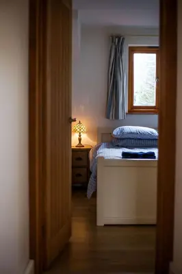 a small bedroom with a bed and a window at Oceans Edge in Portreath