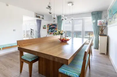 a dining room with a wooden table and chairs at The Lookout in Portreath