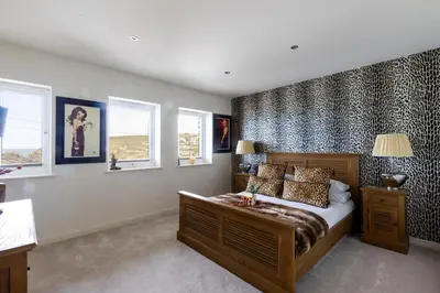 a bedroom with a bed in a room with windows at The Lookout in Portreath