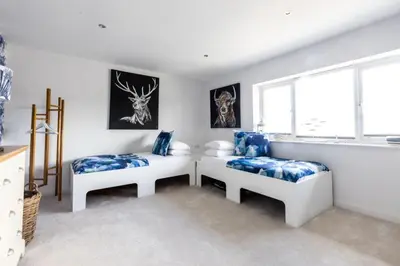 a room with two beds and a window at The Lookout in Portreath