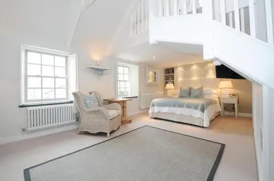 a bedroom with a bed and a desk and a chair at The Tide House in St Ives