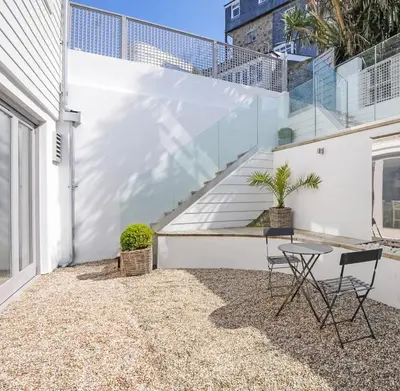 a patio with a table and chairs in front of a building at The Tide House in St Ives