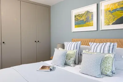 a bedroom with blue and white pillows on a bed at Tamarisk in Portreath
