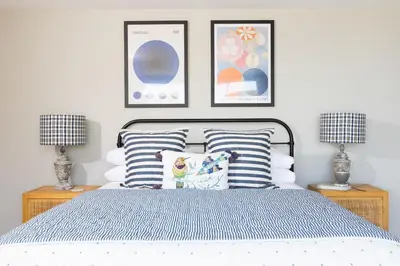 a bedroom with a bed with pillows and two lamps at Tamarisk in Portreath