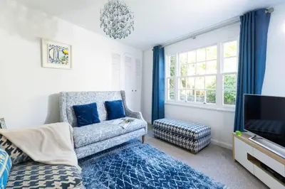a living room with a couch and a tv at The Old Courthouse in Saint Mawes