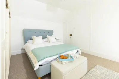 a bedroom with a bed with a blue headboard at The Old Courthouse in Saint Mawes