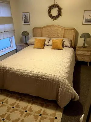 a bedroom with a large bed and two night stands at Entire house by East Looe beach in Looe