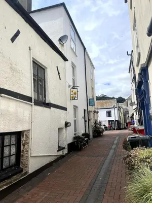 an empty street next to a white building at Entire house by East Looe beach in Looe