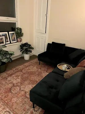 a living room with a black couch and a table at Entire house by East Looe beach in Looe
