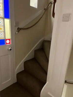 a stairway with stairs with a door and a stair case at Entire house by East Looe beach in Looe