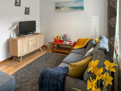 a living room with a couch and a tv at 4 Porth Cottages in Saint Columb Minor