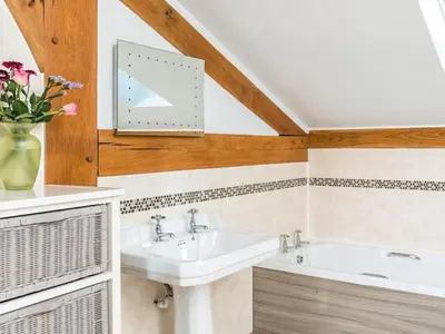 a bathroom with a sink and a tub at The Old Smithy in Bude