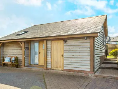 a small wooden building with a bench in front of it at The Old Smithy in Bude