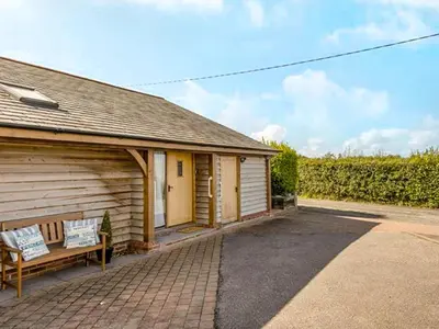a house with a bench next to a building at The Old Smithy in Bude
