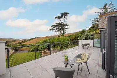 a patio with a table and chairs on a balcony at Watergate View in Porth