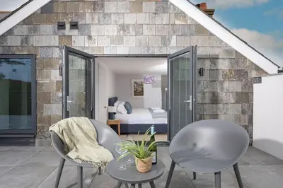 a room with two chairs and a bed at Watergate View in Porth